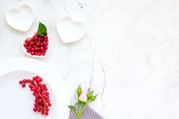 Simple color table setting for celebration with roses, white plates and wineberry on white table background top view mock up
