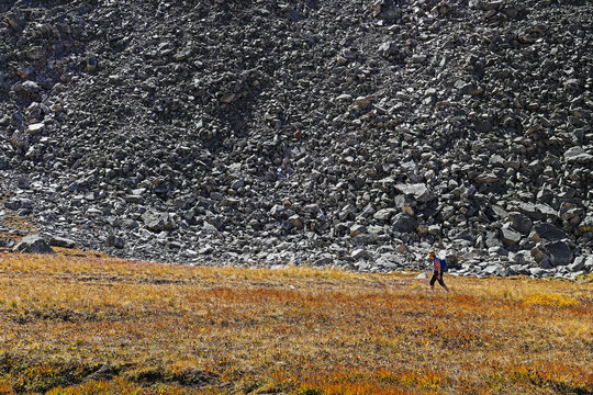 Woman hiking by talus slope in Mayflower Gulch, Colorado