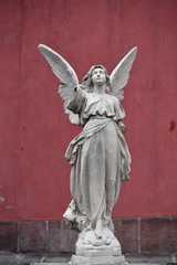 A sandstone sculpture of an angel whose arm has broken off. 