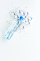 crashed ice cubes with bottle on white kitchen table top view mock up