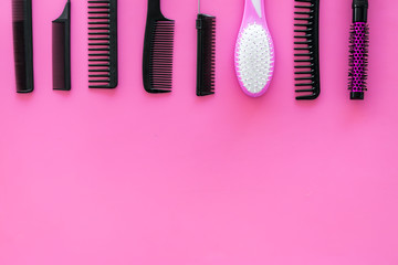 female hairdresser desk with accessories and combs on pink background top view mock up