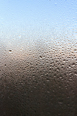 The frozen drops on the patterned frosty winter window