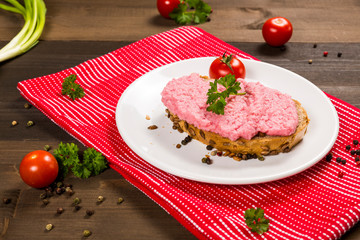 Sandwich with pink paste and tomato on the plate 
