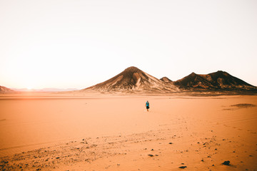 Woman walking along the desert © Trevor