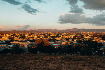 Obraz premium Town with mountains in the distance at sunset