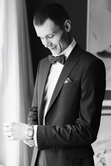 the morning of the groom, a handsome guy in a suit with a bow tie