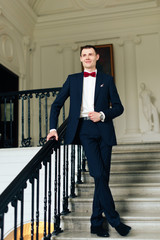 the morning of the groom, a handsome guy in a suit with a bow tie