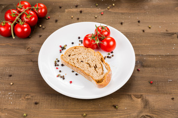 Slice of bread with preserved ham and ingredients. White plate on a wooden background