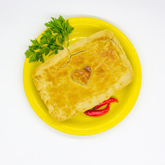 Heart pie with pepper on a yellow plate