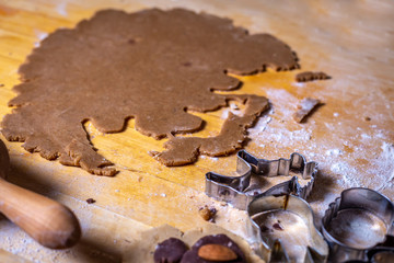 Close up on gingerbread dough and forms, cutters on the wooden table