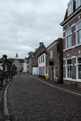 Diminishing perspective of road leading towards Elbow Church against cloudy sky in city