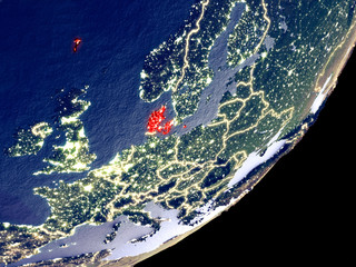 Denmark from space on model of Earth at night. Very fine detail of the plastic planet surface and visible bright city lights.