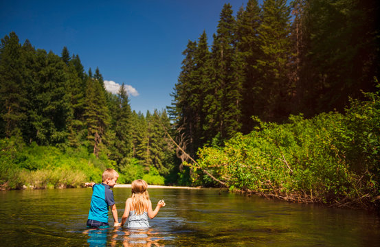 Rear View Of Siblings Standing In River At Okanogan National Forest