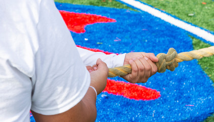 Hands on a rope during tug of war game