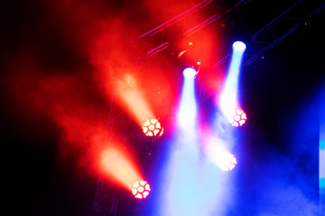 Concert lights, stage, show and excitement.  Light spots in concert, outdoor stage at night, foggy electricity.