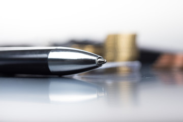 Buchhaltung - Vordergrund Kugelschreiber, Hintergrund Geldsymbol