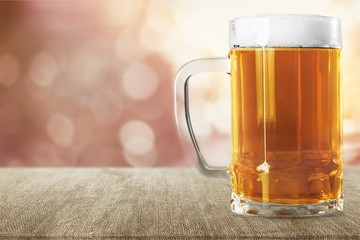 Mug of cold beer with foam, close-up view