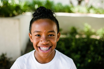 Close-up portrait of cheerful boy standing at park