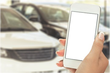 Hand holds phone and car.