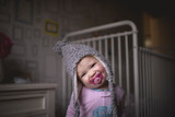 Portrait of girl with pacifier in mouth standing at home