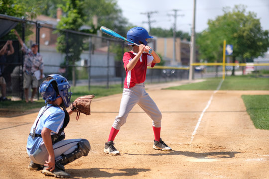 Brothers playing baseball in field