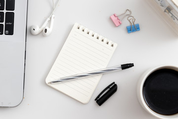 White office desk with notebook and pen