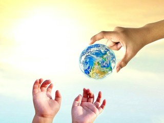 Young man hand holding earth planet for give to child hands with blur sunrise sky background on conservation save earth concept,Elements of this image furnished by NASA