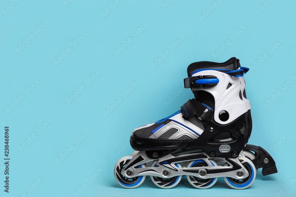 Wall mural pair of inline roller skates on color background. space for text