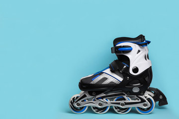 Pair of inline roller skates on color background. Space for text