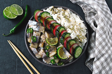 Poke bowl with herring, rice and vegetables. Herring poke bowl. Colorful healthy food.