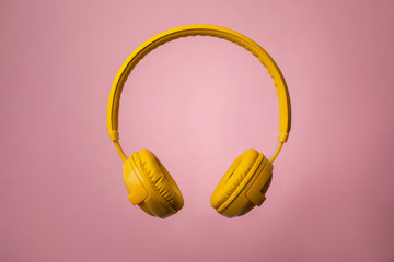 Wireless headphones with earmuffs on color background