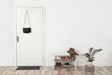 Hall interior with brick wall and white wooden door