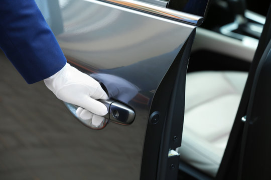 Closeup view of chauffeur opening car door