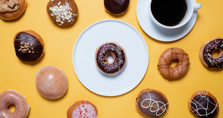 Overhead view of variety of donuts with coffee cup