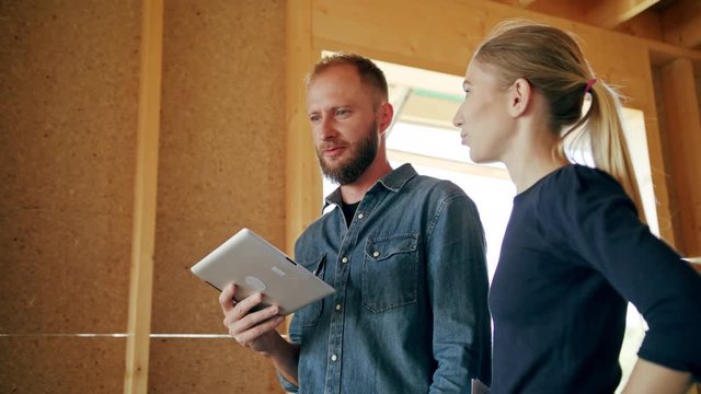 Two young people discussing the construction of a house inside the house. Medium shot. Soft focus