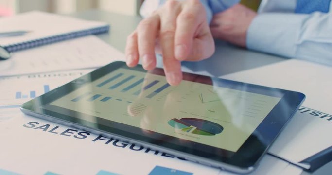 Businessman Using Digital Tablet Over Sales Documents At Desk 4K