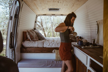 Side view of woman making drink in motorhome