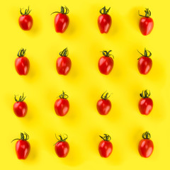Food pattern of cherry tomato  isolated on yellow background. Flat lay, top view.
