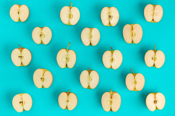Fruit pattern of apple halves on blue background. Flat lay, top view. Food background.
