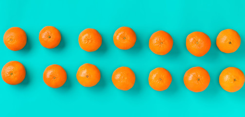 Fruit pattern of fresh mandarin on blue background. Flat lay, top view. Pop art design, creative summer concept. Citrus in minimal style.
