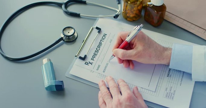 Doctor Writing Rx Prescription On Clipboard By Asthma Inhaler 4K