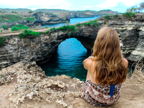 Young Woman Appreciating The View At Broken Beach On Nusa Penida Island In Indonesia. Amazing Landscape And Crystal Clear Water.