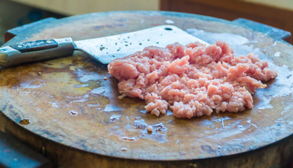 chopping pork. Placed on a wooden chopping board to cook for the next step.