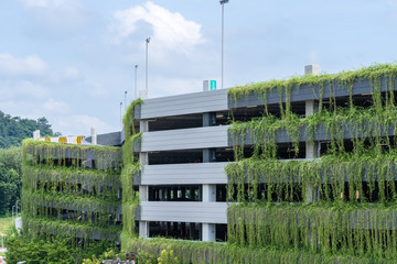 Modern parking garage building covered with plant, exterior decoration.