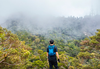 Naklejka premium Men hiking. Mount Ledang Trail, Johor, Malaysia. Selective focus