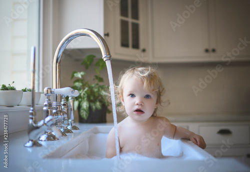 Portrait of girl bathing in sink at home