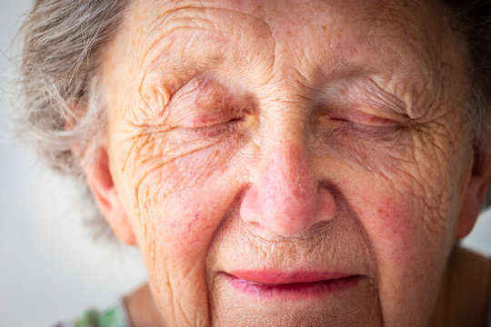 Close-up of sad senior woman with eyes closed