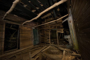 Abandoned wooden house in forest at night