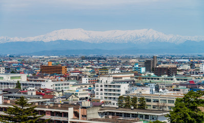 Aerial view of Aizu-Wakamatsu town and snowy mountain behind, Fukushima, Japan.