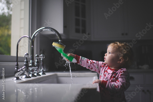 Girl cleaning brush in sink at home